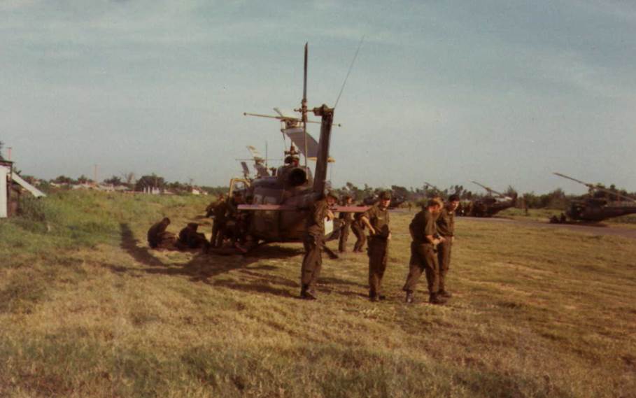 A group of men standing next to a machine in a field

Description automatically generated with low confidence