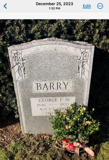 A tombstone with a plant in the background

Description automatically generated
