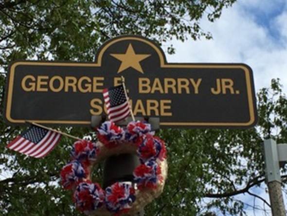 A street sign with flags and a wreath

AI-generated content may be incorrect.