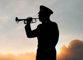 A silhouette of a soldier playing a trumpet

Description automatically generated