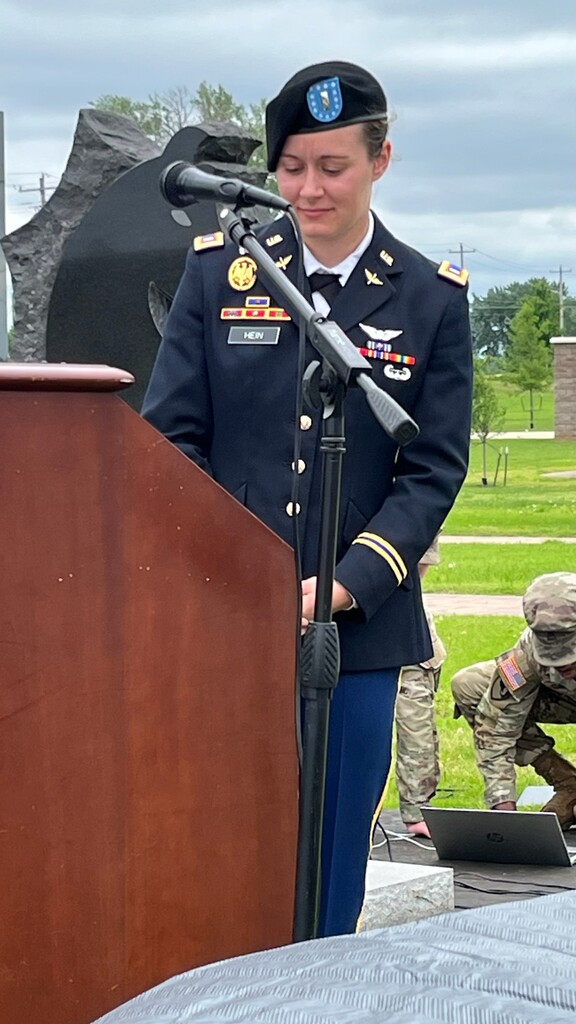 A person in military uniform standing at a podium

Description automatically generated with medium confidence