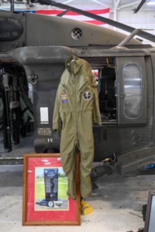 A suit on a stand in front of a helicopter

Description automatically generated