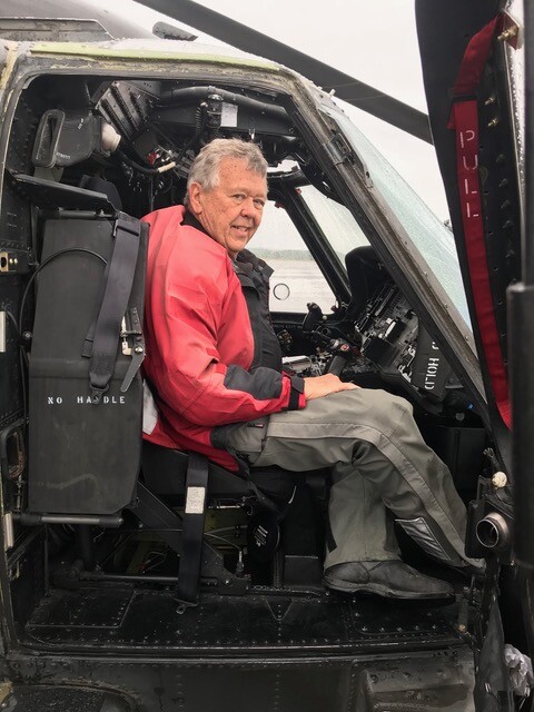 A person sitting in the cockpit of a helicopter

Description automatically generated
